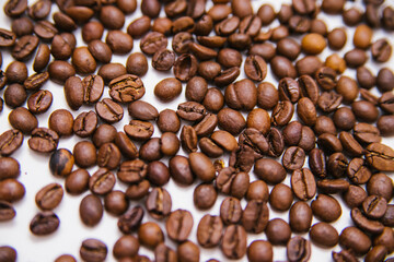 Coffee beans are scattered on a white background. Roasted coffee beans. Background.