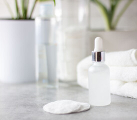 Home care for the face and body.Natural cosmetic product in a glass bottle. In the bathroom on the background of a white fresh towel.