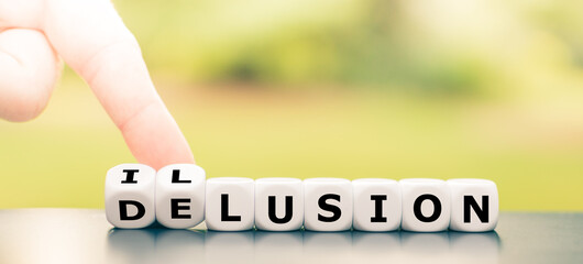 Hand turns dice and changes the word delusion to illusion.