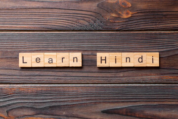Learn Hindi word written on wood block. Learn Hindi text on table, concept