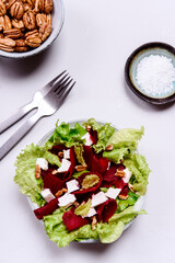 Beetroot, feta cheese and pecans salad on grey concrete table. Selective focus