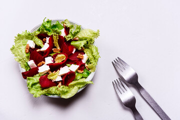Beetroot, feta cheese and pecans salad on grey concrete table. Selective focus