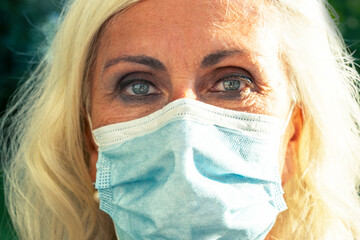 close-up portrait Gorgeous European woman wears a face mask to protect herself from coronavirus....