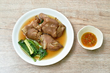 boiled slice pork leg and foot with Chinese kale in black herb soup on plate
