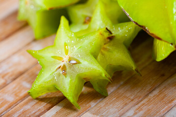 Fototapeta premium Carambola fruit on wooden table closeup. Vitamin fruits