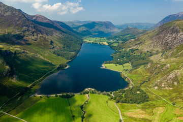 Aerial view of a beautiful lake in a narrow valley surrounded by tall mountains (Buttermere)