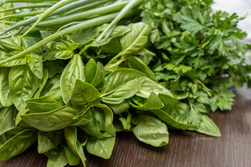 Greens, basil, parsley, onion close-up on the table