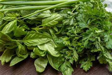 Greens, basil, parsley, onion close-up on the table
