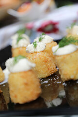 potato canapé with sour cream and micro herbs.
