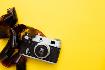 retro camera and photographic film on yellow background, copy space
