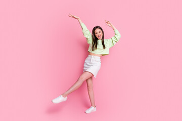 Full size photo of attractive funky lady excited dance disco hit youth party dancer wear casual green crop pullover naked belly jeans short skirt shoes isolated pink pastel color background