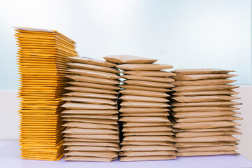 Pile of Different sizes brown envelopes preparing the send on white background.