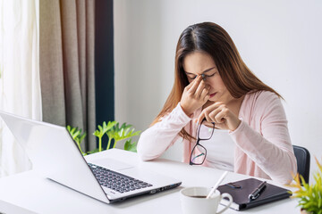 Tired and stressed young asian woman feel pain eyestrain and rubbing her eyes and take off her...