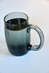 grey glass with water standing on white table