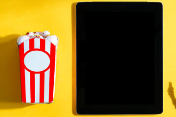 Holiday movie screening at home with Halloween corn and tablet.