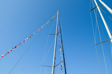 Fototapeta premium Yacht mast with multi-colored flags
