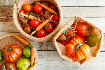 Basket with a variety of baby carrots and tomatoes, including: Cherry, Heirloom and Zebra.