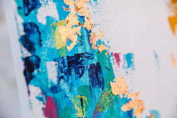 Closeup of a colorful abstract painting with golden foil on canvas.
