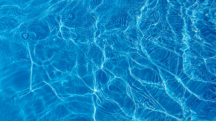 Fototapeta na wymiar The water in the pool is blue, penetrated by the rays of the sun. Selective focus. Healthy lifestyle. Vacation for children.
