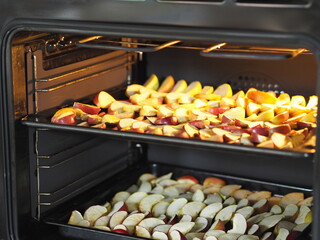 The process of drying apples in the kitchen oven on baking sheets. Homemade dried fruits for future use.