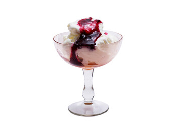 A bowl of white ice cream drizzled with jam and sprinkled with raspberries.