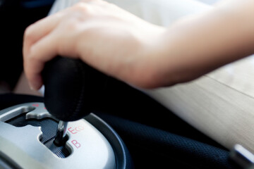 シフトレバーを操作する女性の手元