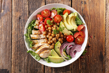 grilled chicken, chickpea, avocado and tomato- vegetable salad with chicken in bowl
