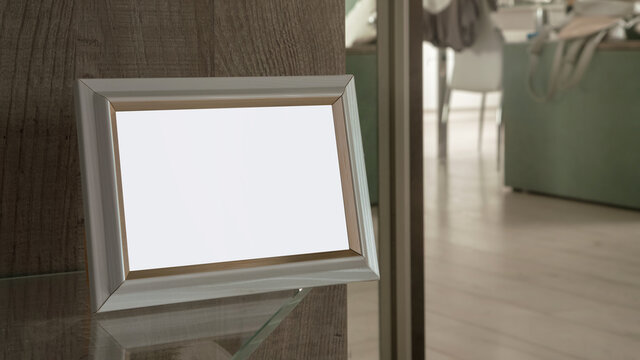empty wooden photo frame with blank mockup space stand on glass shelf in room