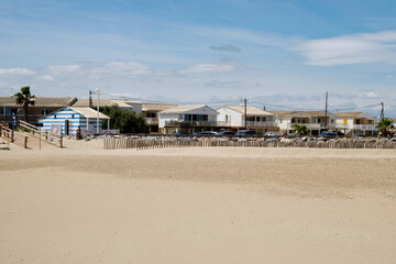 Obraz premium The beautiful seascape - the magnificent view of the seashore, coast of the Mediterranean sea and the lonely beach with wooden cottage in the seaside resort of Gruissan, France