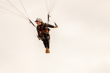 woman flying paraglider at cloudy sky
