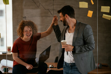 Businesswoman and businessman discussing work in office. Two friends in working together.