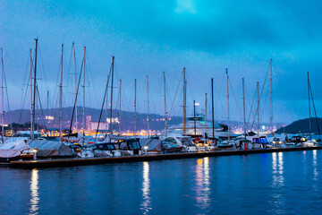 Fototapeta na wymiar Harbour with yachts in downtown of Oslo at Oslofjord sea waterfront. Evening seascape.