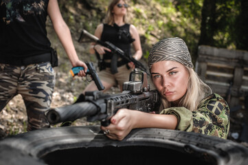 Fototapeta premium Combat team squad of attractive female military soldier have war training. Woman with weapon. Special forces. Outdoor shooting range