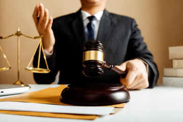 Business and lawyers discussing contract papers with brass scale on desk in office. Law, legal services, advice, justice and law concept picture with film grain effect