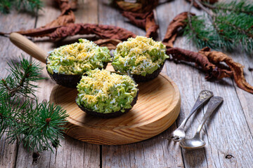 Avocados stuffed with tuna on rustic background