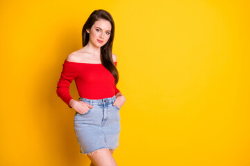 Photo of cute lovely young lady arms pockets standing empty space look posing student attract guys wear shirt uncovered shoulders denim mini skirt isolated bright yellow color background