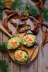 Avocados stuffed with tuna on rustic background