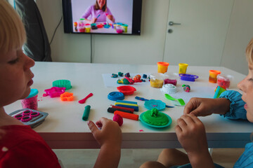 Kids play with clay molding shapes during online lesson