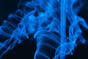 Fototapeta premium Blue abstract shaped smoke against black background. Abstract background