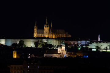 Obraz premium light from street lights and reflections of lights on the road in the center of the old town of Prague at night in the Czech Republic