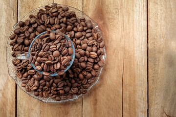 blue cup with coffee beans on a rustic wooden table with top view with copy for text 