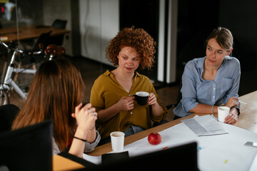 Fototapeta premium Businesswomen working on a new project. Colleagues discussing about problem they have to solved.
