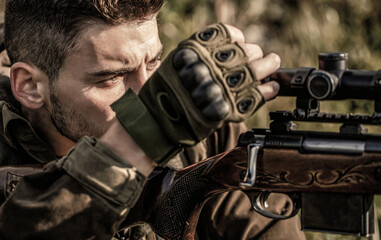 Hunter is aiming. Shooter sighting in the target. The man is on the hunt. Hunt hunting rifle....