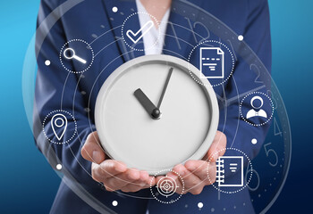 Time management concept. Woman holding clock surrounded by icons, closeup
