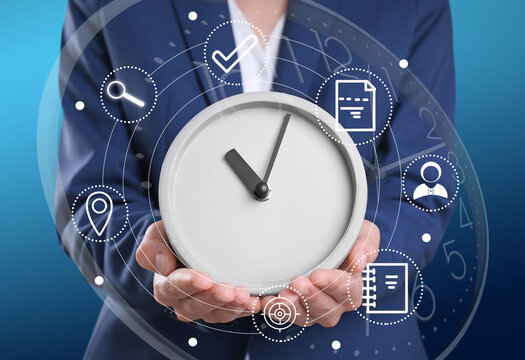 Time management concept. Woman holding clock surrounded by icons, closeup