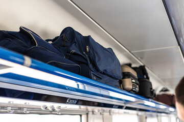 Luggage on shelf railway train. Holiday vacation, tourism, travel, modern train interior, of...