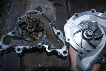 replacement of the car water pump, old and new pumps with metal blades.