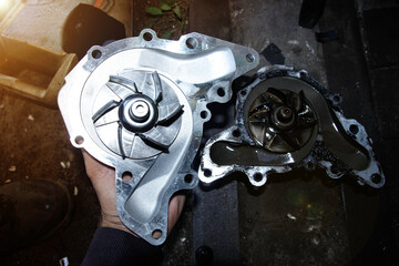 replacement of the car water pump, old and new pumps with metal blades.