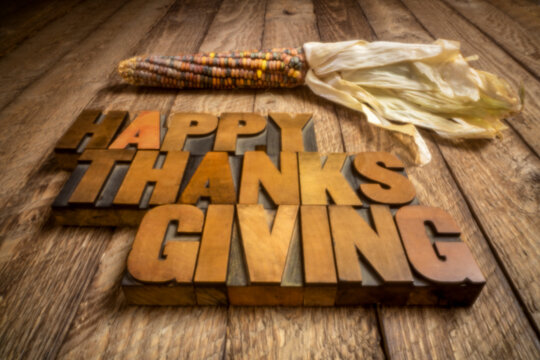 Happy Thanksgiving in vintage letterpress wood type with a decorative corn, soft focus image shot with a lensless pinhole camera