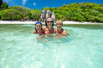 Young girl with mother and grandmother relaxing in the water, Seychelles Islands